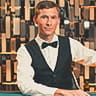 A live casino dealer at a poker table.