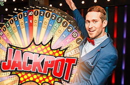 A man about to spin a Jackpot lottery wheel.
