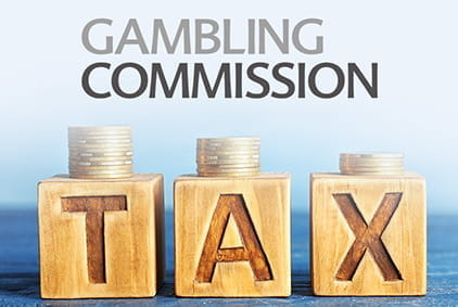 Gambling commission's logo and wood block spelling the word tax.