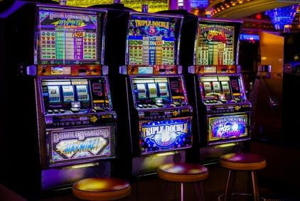 A row of three slot machines in a casino.