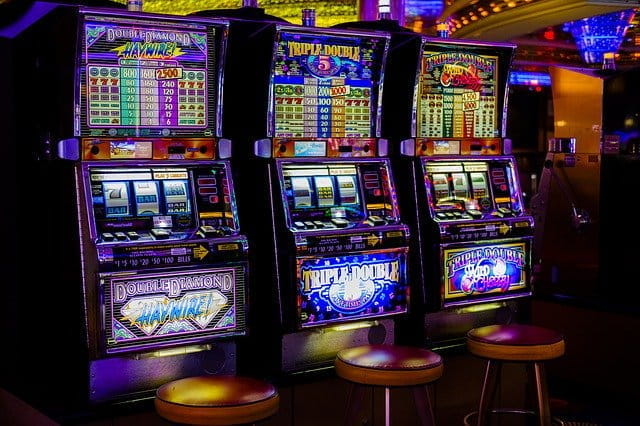 A row of three slot machines in a casino.