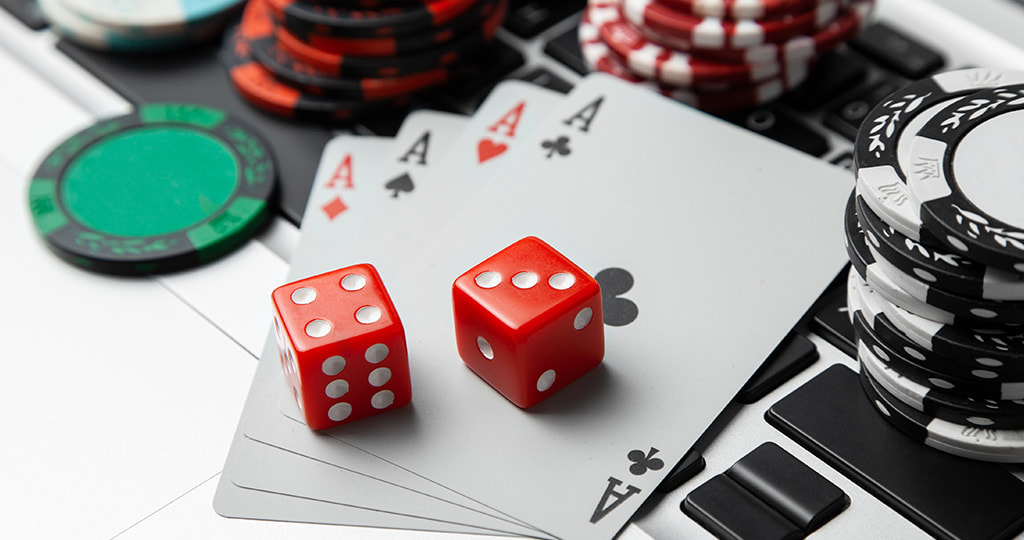 Chips and playing cards surrounding a laptop