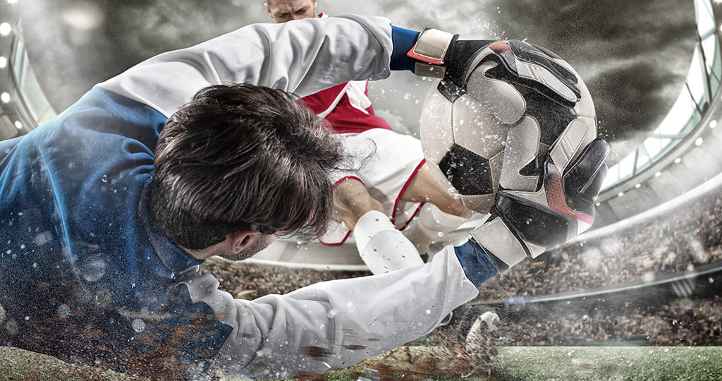 A goalkeeper holding a footbal