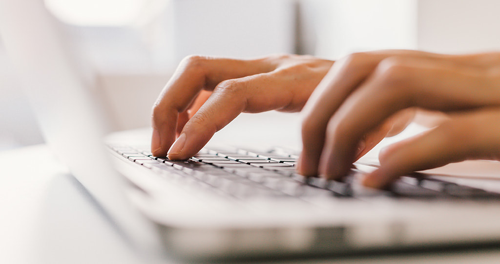 Hands typing on a computer keyboard 