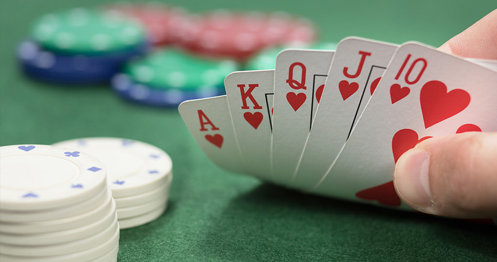 A stack of betting chips alongside playing cards