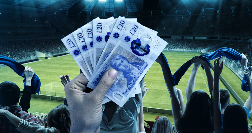 Hand waving cash at a football