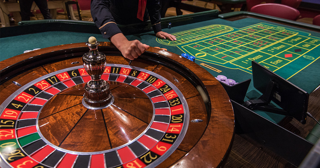 A hand rolling dice on the roulette betting table 