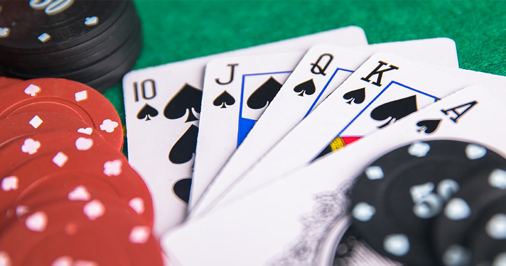 Cards being lifted in front of stacked poker chips 