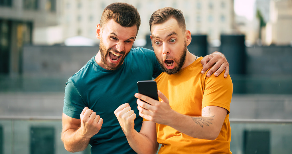 A clenched celebrating fist next to a mobile phone