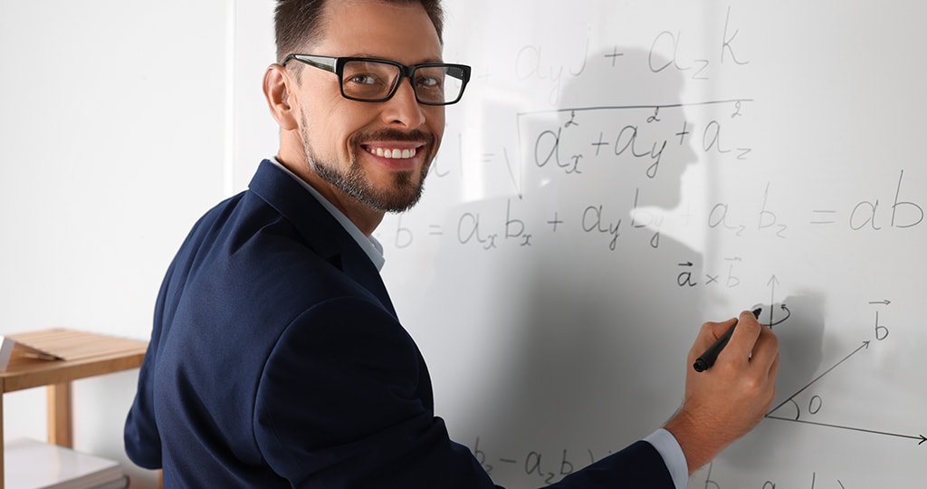 Two people performing calculations on a whiteboard