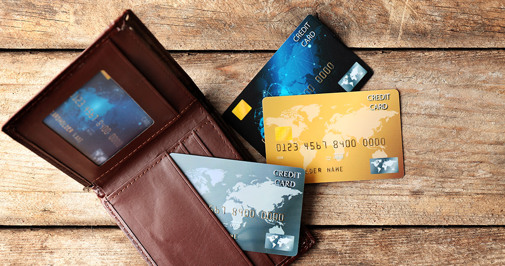 A wallet with credit cards sitting on a desk