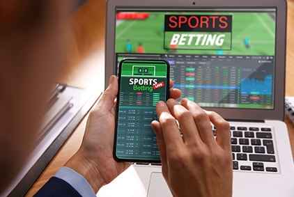 A human hand scrolling through a sports betting interface